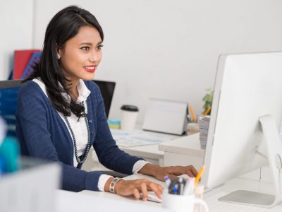 Filipina business lady busy with work on computer